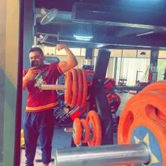A quick flex after a good session. This client is showing the results of his arm workout. Building muscle mass requires consistent effort and heavy lifting, and he is putting in the work.