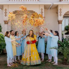 The bride and her bridesmaids enjoying a shower of flower petals during the Haldi. These are the vibrant, happy photos that perfectly capture the celebratory mood.