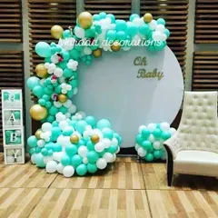 This 'Oh Baby' setup uses a refreshing color palette of teal, white, and gold. The design includes a circular backdrop, 'BABY' blocks, and a comfortable chair for the mom-to-be, making it a perfect photo corner.