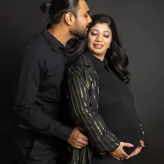 A tender kiss on the forehead makes for such a sweet and glamorous couple portrait. The all-black outfits with the hint of sparkle from her jacket create a cohesive and stylish look against the dark backdrop.