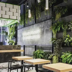 The right plants can completely define the mood of a space. For this modern restaurant, we used a variety of hanging ferns and wall-mounted greenery to complement the industrial-chic interiors, creating an inviting and memorable dining experience.