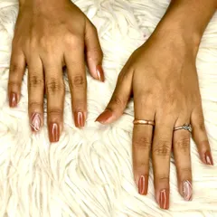 A warm brown gel polish on square-shaped extensions, featuring a geometric accent nail with negative space for a modern touch.