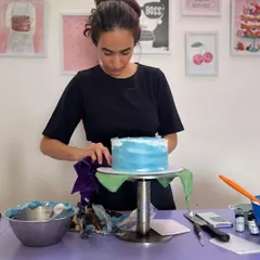 A moment of focus while frosting a cake. Getting that smooth finish is one of the most satisfying parts of the process.