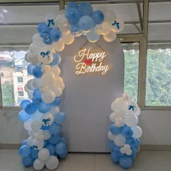 The little bow details on the balloons add a charming and cute element to this blue and white setup.