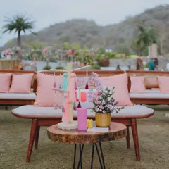 A cozy lounge area from the soirée, with a rustic coffee table, pink cushions, and a tassel tree centerpiece, creating a relaxed and stylish vibe.