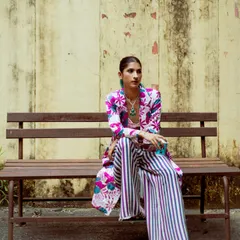 A quiet moment on a bench, but the outfit is still loud. This shows that even the most vibrant festive wear can have a relaxed and effortless feel.
