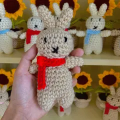 A close-up of one of my handmade amigurumi bunnies with a bright red scarf.