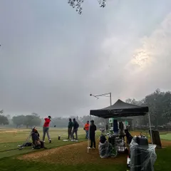 A busy morning at a demo day event. Golfers gather under the tent to test new equipment and get advice from brand representatives on a hazy weekend morning.