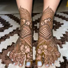 An intricate design for the feet, matching the level of detail seen in bridal hand mehendi. This pattern uses a mix of florals and jaali work.