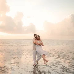 A playful and joyous moment on a Goan beach, with the groom lifting the bride as the waves reflect the soft sky. This captures the fun, relaxed vibe of a coastal pre-wedding shoot.
