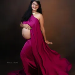Be the princess of your own fairy tale. This expecting mother looks radiant in a flowing magenta gown and crown, a perfect way to celebrate the magic of pregnancy.