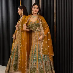 A full shot of the mustard and green lehenga, showing its beautiful drape and the reflection in the mirror. A truly photogenic outfit for your special events.