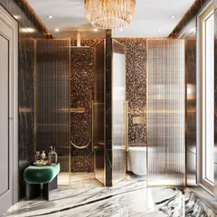 The shower area of the same bathroom, enclosed by fluted glass panels with gold trim. The space includes a built-in seat and uses a mix of black marble and textured terrazzo walls.
