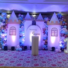 A royal celebration for Princess Tiara. This stage features a custom-built castle backdrop with towers and windows, flanked by Disney princesses like Cinderella and Aurora, and lit with dramatic blue and purple lights.