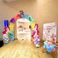 A colorful balloon arch and welcome sign for a unicorn-themed birthday. The rainbow-colored balloons and unicorn cutouts create a cheerful and inviting entrance for the party guests.