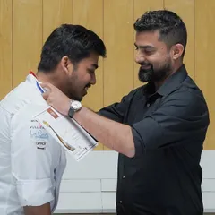 Chef Avin, the mentor for our Mondial Du Pain team, places a medal on his student. The bond between our mentors and students is at the heart of our academy's success.