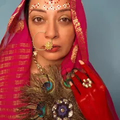 The direct gaze in this Radha-inspired look is powerful. The focus is on the traditional jewelry and the symbolic use of color and adornment to tell a story of devotion and beauty.