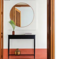 This image of an entryway I designed was featured on the cover of a magazine. The minimalist black metal console table, round mirror, and terracotta-colored wall create a simple yet powerful composition.
