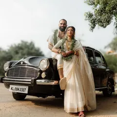 A stylish couple portrait against the backdrop of a vintage Ambassador car. We love incorporating unique elements into our shots, blending classic elegance with modern style for truly memorable South Indian wedding photography.