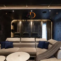 This dedicated home theatre room features plush, comfortable seating, including recliners, and is acoustically treated for an immersive cinematic experience.