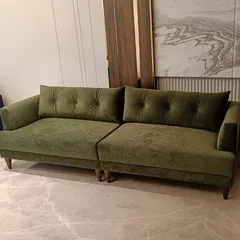 We crafted this deep green sofa with plush, tufted back cushions for a client seeking both comfort and a touch of color. The solid wood legs and rich velvet fabric make it a durable and stylish addition to any living space.