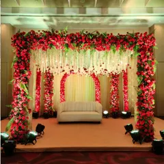 For a bold and passionate statement, we use a rich palette of red roses to create a stunning mandap and stage. The design features a canopy of flowers and hanging floral strings, enveloping the couple in traditional elegance.