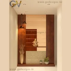 This foyer design uses a combination of wooden panels and a bronze mirror to create a frame-like effect. The space is designed to welcome guests with a Ganesha idol, warm pendant lighting, and a mix of plants and vases.