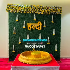 We can blend modern and traditional elements, like this grass wall backdrop paired with a classic brass `urli` for the Haldi ceremony rituals.