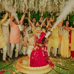 The couple makes a grand statement at their Haldi ceremony, surrounded by friends and celebratory smoke cannons.