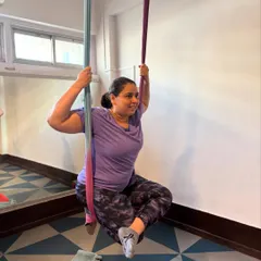 Finding joy in the journey. This student’s smile captures the supportive and encouraging atmosphere we cultivate in every aerial yoga class.