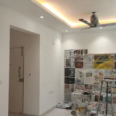 This image shows a room after the first coat of paint, with all the prep work visible. We use newspaper and sheets to protect built-in furniture and fixtures, ensuring clean lines and no mess.