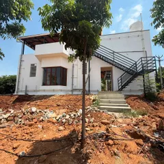 A look at the rear of the property, showing the external staircase that provides access to the upper floor. This is a practical design choice that also adds a modern, industrial touch to the home's exterior.