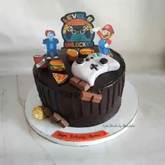 Game on. This 'Level 8 Unlocked' cake is perfect for a young gamer, featuring a controller, characters like Mario, and edible junk food snacks.