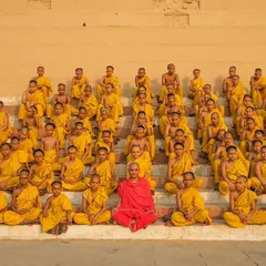 A moment of quiet contemplation as young Batuks, or student monks, sit in perfect formation on the steps of a Varanasi ghat. The single figure in red is their teacher, a beacon of knowledge.