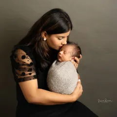 The bond between a mother and her newborn is pure magic. I focus on capturing these quiet, tender moments of love, like a gentle kiss on the forehead, that you will cherish forever as a natural family newborn portrait.