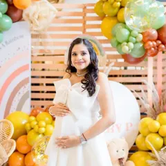 A full-length shot showing her stunning white dress and the joyful decor. The makeup is subtle and elegant, perfect for this happy occasion.
