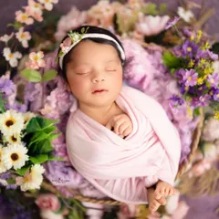 For this shot, I used a simple pink swaddle to create a beautiful contrast with the surrounding purple and white flowers. This classic newborn pose is always a favorite among parents.