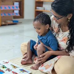 I believe in a gentle start. A parent sits with their child, offering comfort and support as he explores a new puzzle. This partnership is key to building a bridge of trust between home and school.