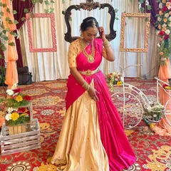 This client looks stunning in a custom lehenga saree I designed for her baby shower. The beige silk skirt is paired with a hand-embroidered blouse and a vibrant pink dupatta draped like a saree pallu.
