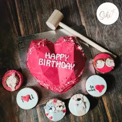 This geometric heart piñata cake is made to be smashed. It comes with a mini hammer and is paired with adorable custom cupcakes featuring teddy bears and couple portraits.