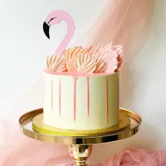 A simple and chic flamingo cake. The design uses a pink chocolate drip and piped buttercream "feathers" to create the flamingo's body, with a paper topper for the head.