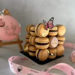 A close-up of the stacked macarons, showing the gold leaf detail and the custom-stamped macaron with my logo.