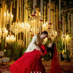 A cinematic moment captured under a sky of cascading mogra and crystal chandeliers. We designed this backdrop for a timeless varmala ceremony, where the bride's radiant red lehenga stood out against the soft ivory, creating a memory as eternal as their love story.