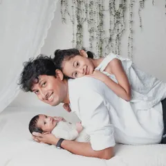 Dad joins in on the fun. A playful moment with a father, his daughter, and his newborn baby, creating a happy and dynamic family photo.