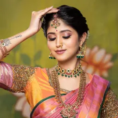 A close-up from a creative shoot, highlighting the detailed eye makeup and the traditional jewellery. The pose is elegant and showcases the makeup beautifully.