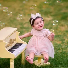Surrounded by bubbles, this little pianist is all smiles. I use fun elements like a bubble machine to create a playful and engaging atmosphere during my themed toddler photoshoots.