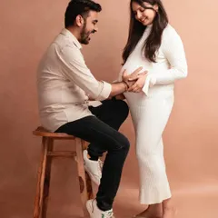 A playful and happy moment between this expecting couple. The simple studio setup keeps the focus on their connection and joy.