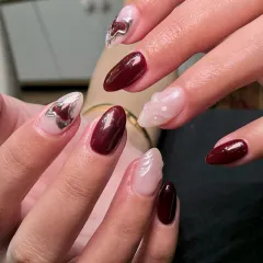 A sophisticated and modern design combining deep maroon, a sheer nude base, and abstract silver chrome accents. The sculpted white nail adds a touch of texture.