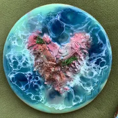A close-up of a heart-shaped resin coaster. These small, functional art pieces are a great way to bring a piece of the ocean into your home.