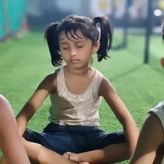 Finding her center. A young girl practices meditation, learning to calm her mind and improve focus, skills that are valuable both in and out of the gym.